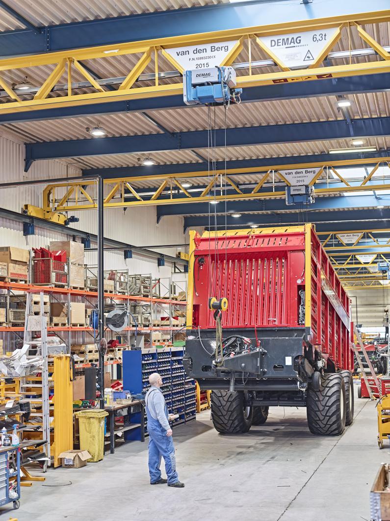 The fittings of the agricultural machinery are positioned by the cranes for installation.