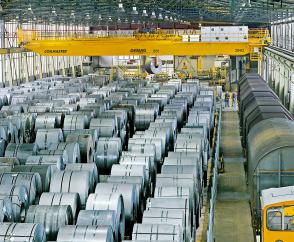 Demag Prozesskran mit Coilzange übernimmt das Handling von Stahlcoils im vollautomatisierten Rohmateriallager eines Kaltbandherstellers.