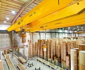 Sieben vollautomatisierte Krananlagen mit Vakuumheber in einem Versandlager für Papierrollen