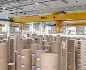 Bis zu vier Rollen mit einem Griff: Vollautomatisierte Lagerung von Papierrollen mit einem mechanischen Greifersystem.