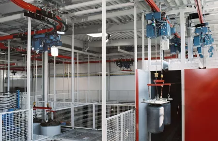 Teilautomatisierte KBK-Ringbahn mit Absenkstationen für die Produktion von Warmwasserbehältern