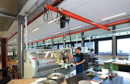 Kran mit DC-Kettenzug für das Handling von Werkstücken an einer Bearbeitungsmaschine