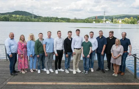 Die Auszubildenden, der Betriebsrat und die Personalabteilung von Demag stehen für ein Gruppenbild zur Freisprechung vor dem Harkortsee in Wetter.