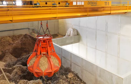 Ein 11-t-Prozesskran sorgt für die Einlagerung von Holzschnitzeln und führt diese kontinuierlich dem Verbrennungsofen zu